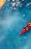 Two people in a canoe navigating forest river 