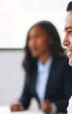 A close up of a male in business clothes with a smiling face. 